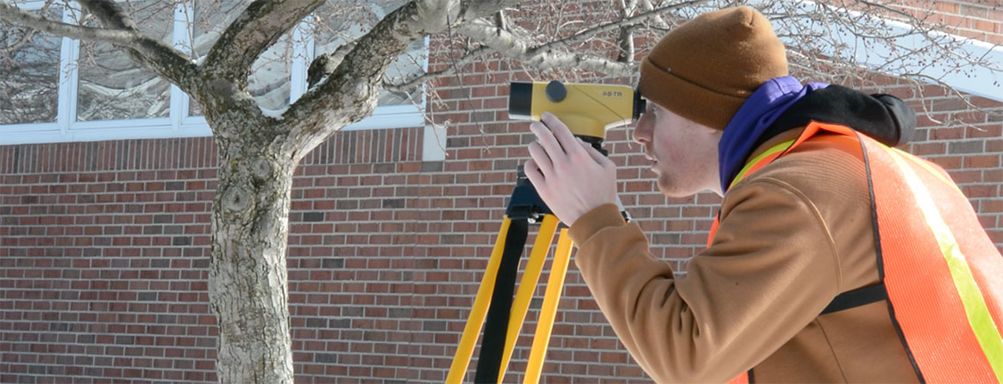 Civil engineering student using surveying equipment